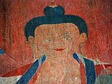 Lo Manthang Thubchen 03-2 Entrance Left Wall Painting Of Buddha Close Up The Nova Lost Treasures Of Tibet DVD had already told me about the restoration of the abandoned Thubchen gompa and its paintings. British architect John Sanday led the restoration of the Gompa roof in the traditional way with wood, flat stones and mud. Art conservator Rodolfo Lujan from Rome led the restoration of the paintings using the same techniques as the Sistine Chapel. Buddhas face glows with the restored red, green and blue colours on the left wall before the assembly hall entrance door at Thubchen Gompa in Lo Manthang.